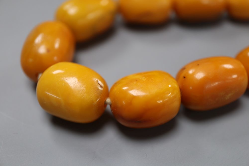 A single strand oval amber bead necklace, 74cm, gross weight 128 grams,